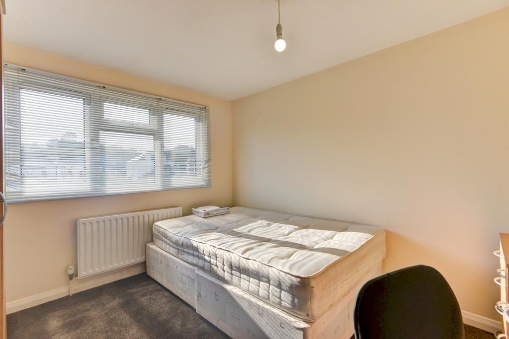 Bright, simply furnished bedroom with a comfort...