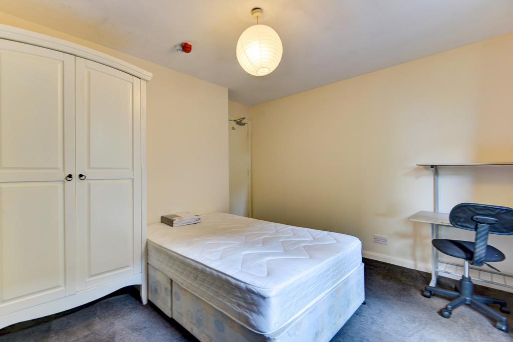 A tidy and well-lit bedroom featuring a single ...