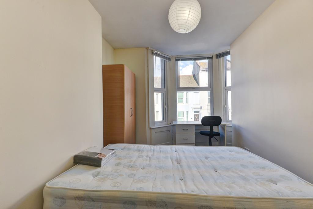 A bright, spacious master bedroom featuring a c...