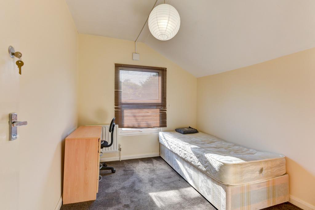 A simple single bedroom with a comfortable bed,...