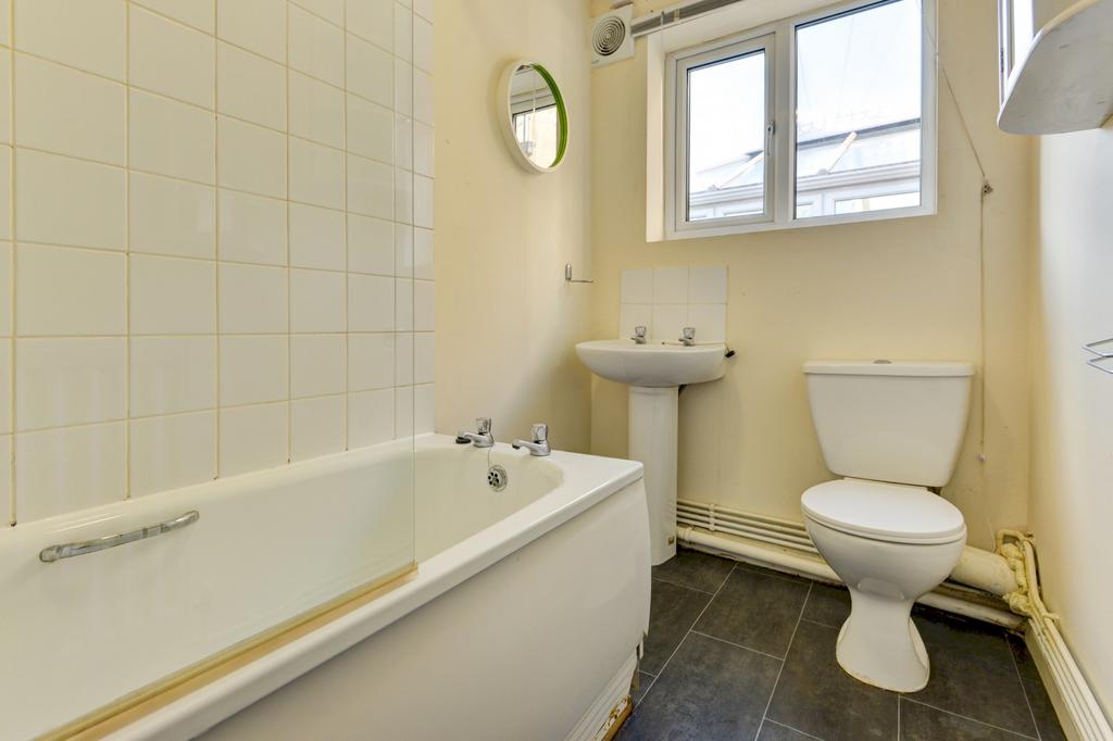 A functional bathroom with a bathtub, toilet, a...