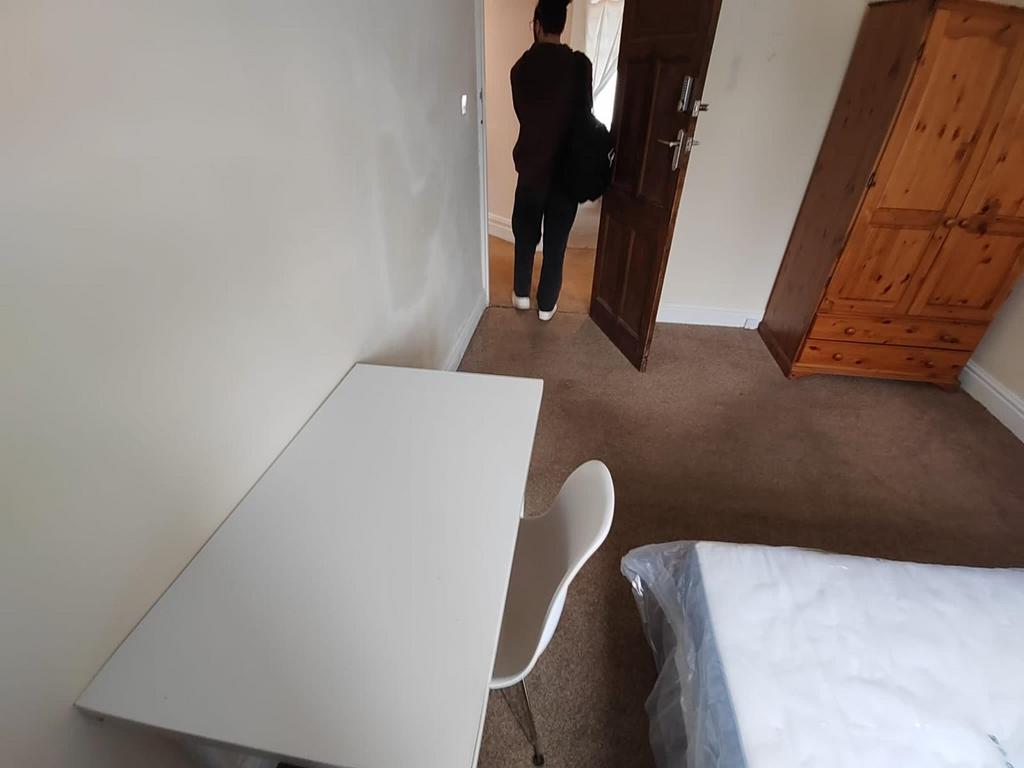 Bright, simply furnished bedroom with a study d...