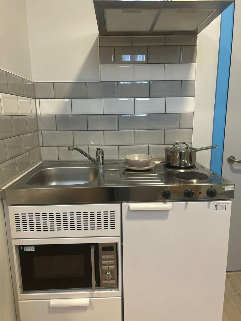 Compact, modern kitchenette with stainless-stee...