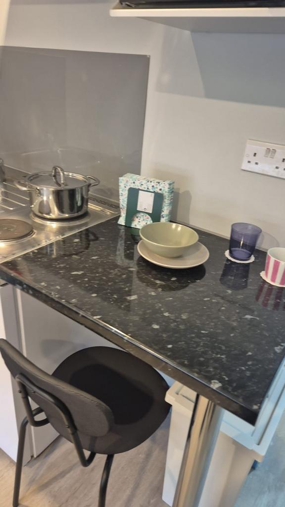 Contemporary kitchenette with a dark speckled b...