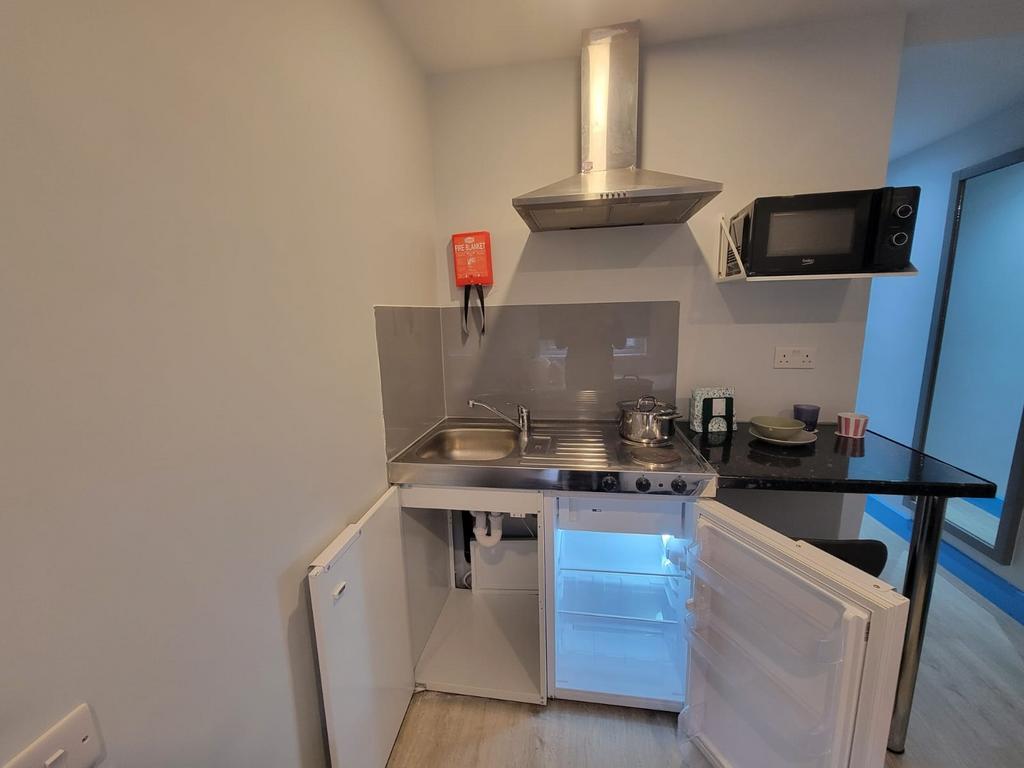 Compact modern kitchenette with stainless-steel...