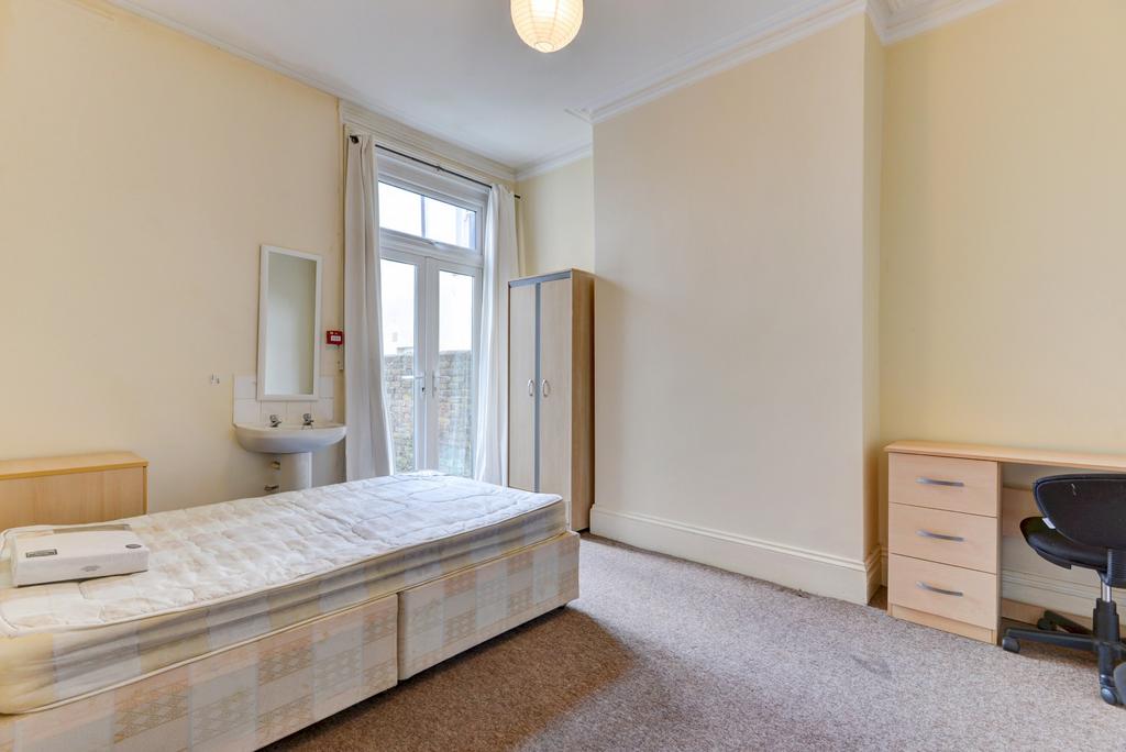 Bright double bedroom with high ceilings, a sin...