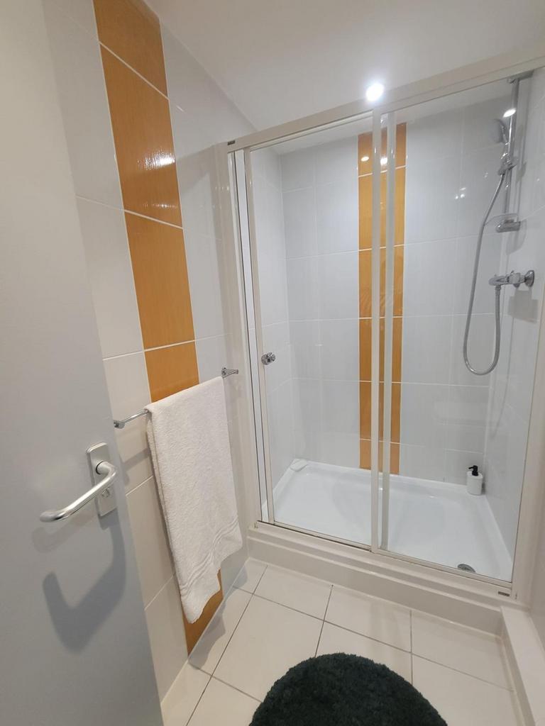 Modern tiled bathroom with a walk-in shower enc...