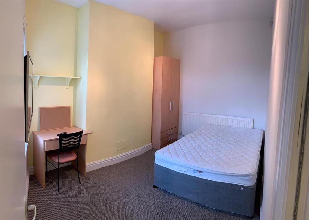 Bright, simply furnished bedroom with a comfort...