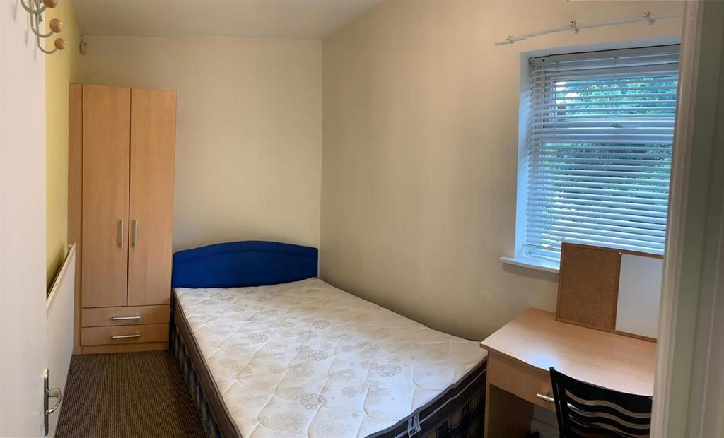 Bright, simply furnished bedroom with a single ...
