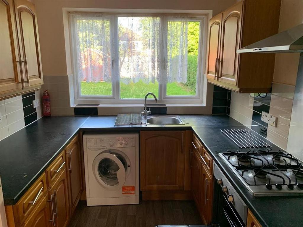 Bright galley kitchen with a wide window over t...