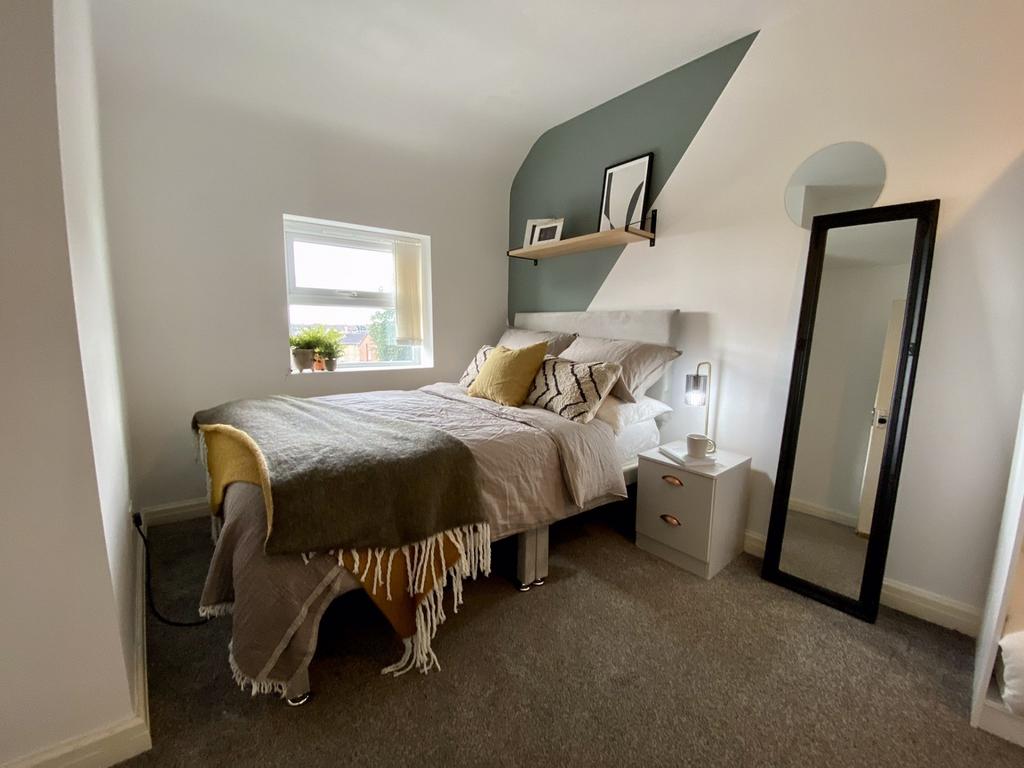 A cozy and well-lit double bedroom featuring st...