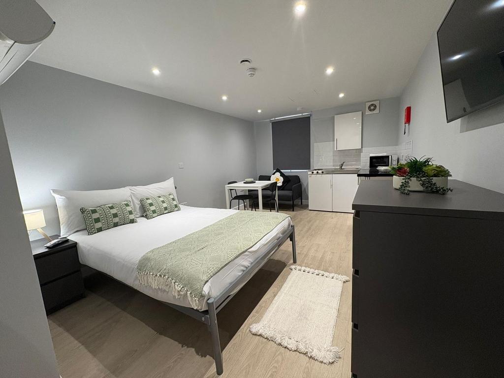 Bright, modern studio-style bedroom with a comf...