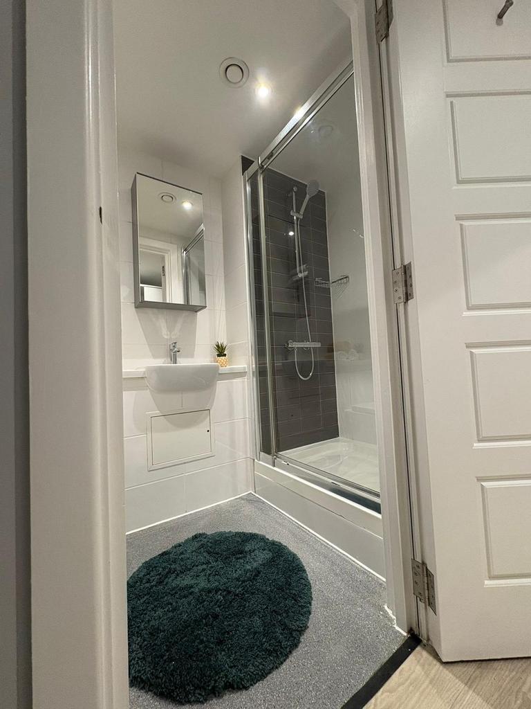 Modern bathroom with a glass-enclosed shower, w...