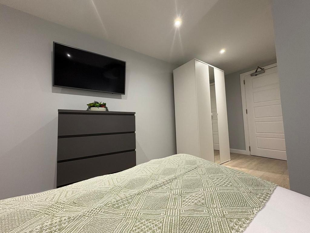 Well-presented bedroom with a wall-mounted TV, ...