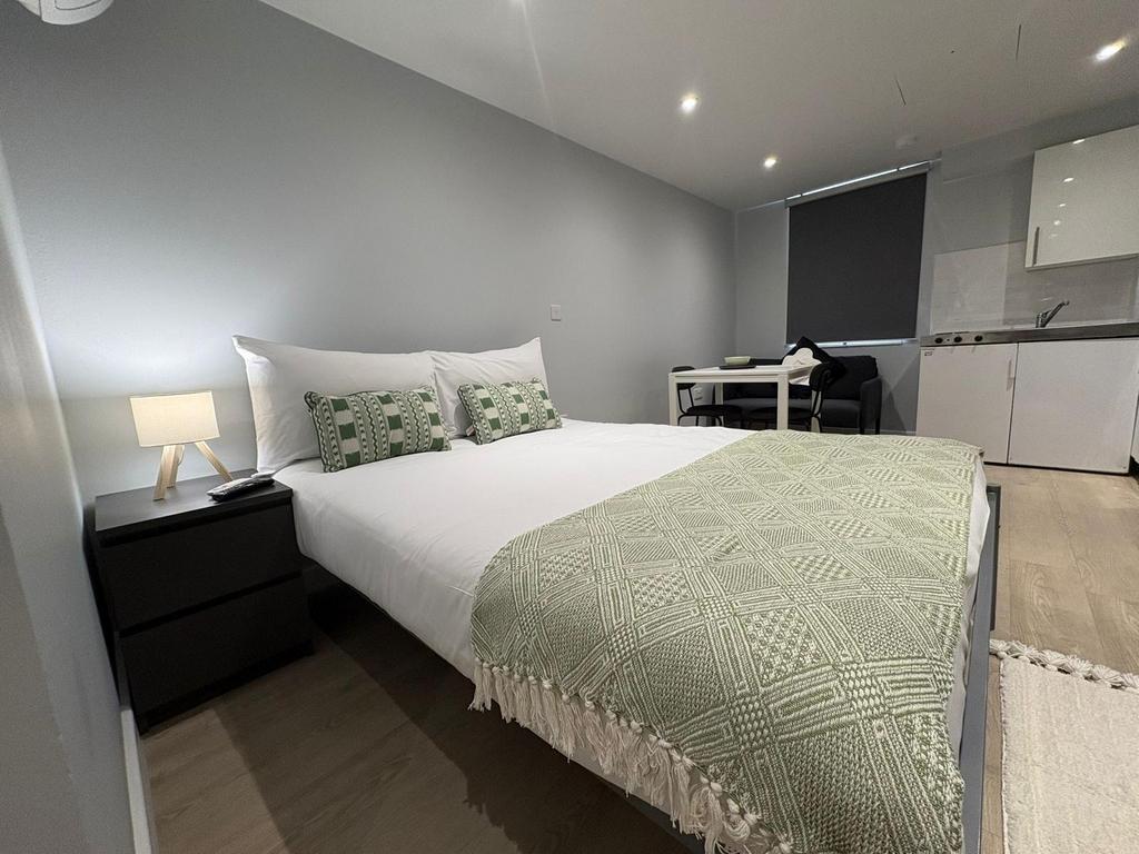 Bright, modern double bedroom with a neatly mad...