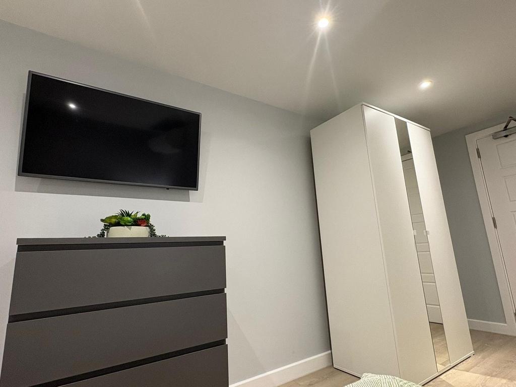 Bright, simply furnished bedroom with a wall-mo...