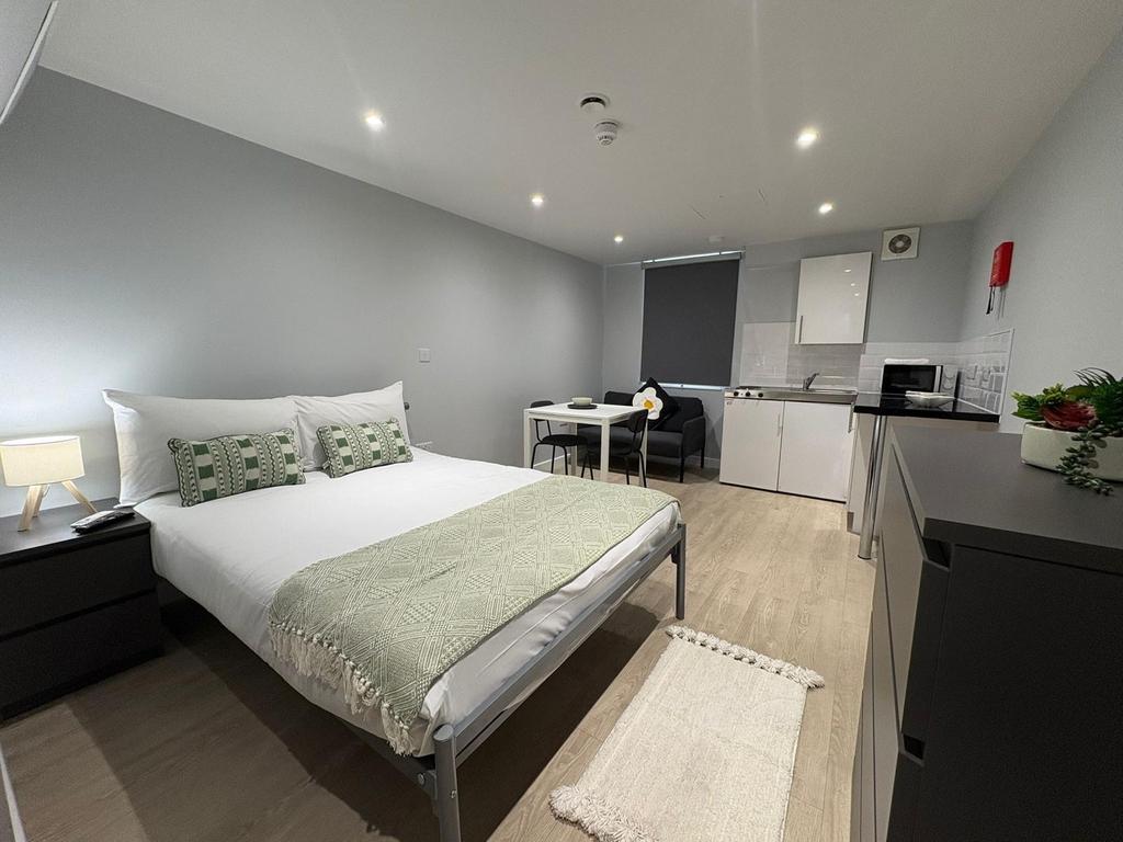 Bright, modern studio with a neatly made double...