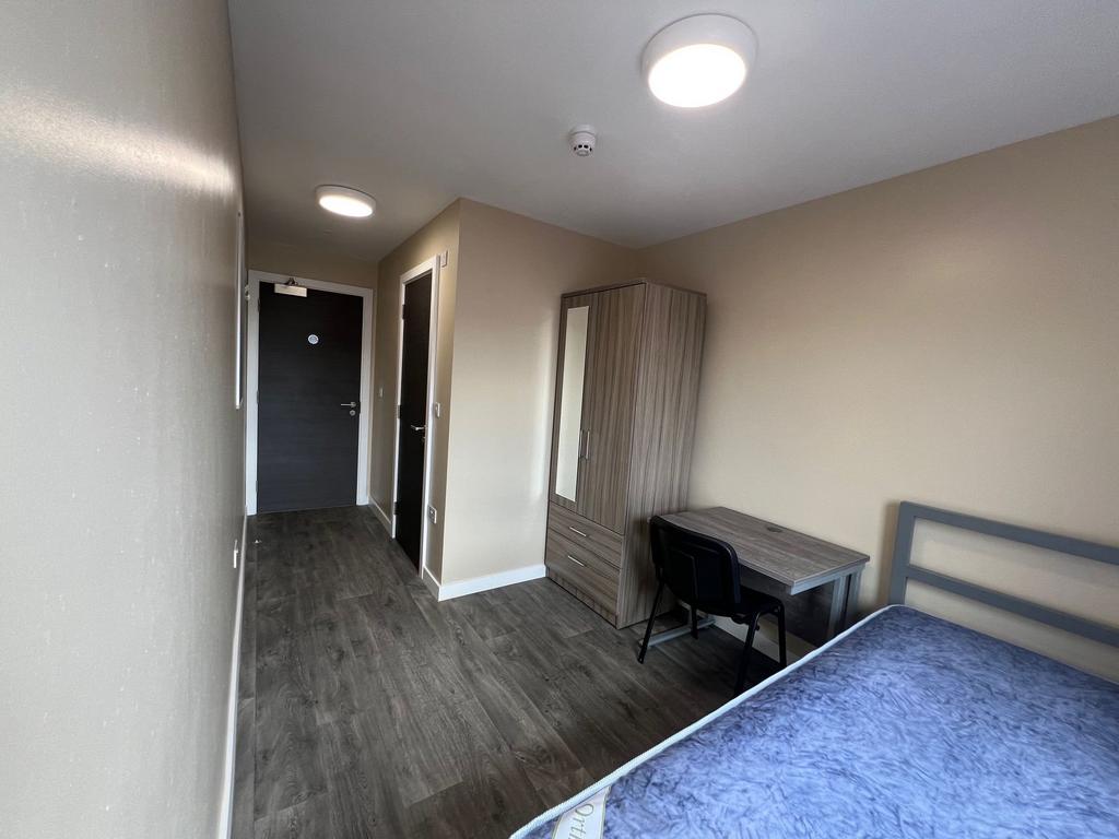 A well-lit, modern bedroom featuring a double b...