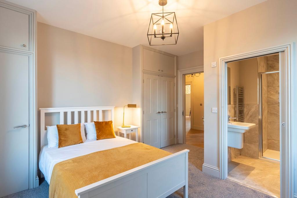 Bright, well-styled bedroom with a white wooden...