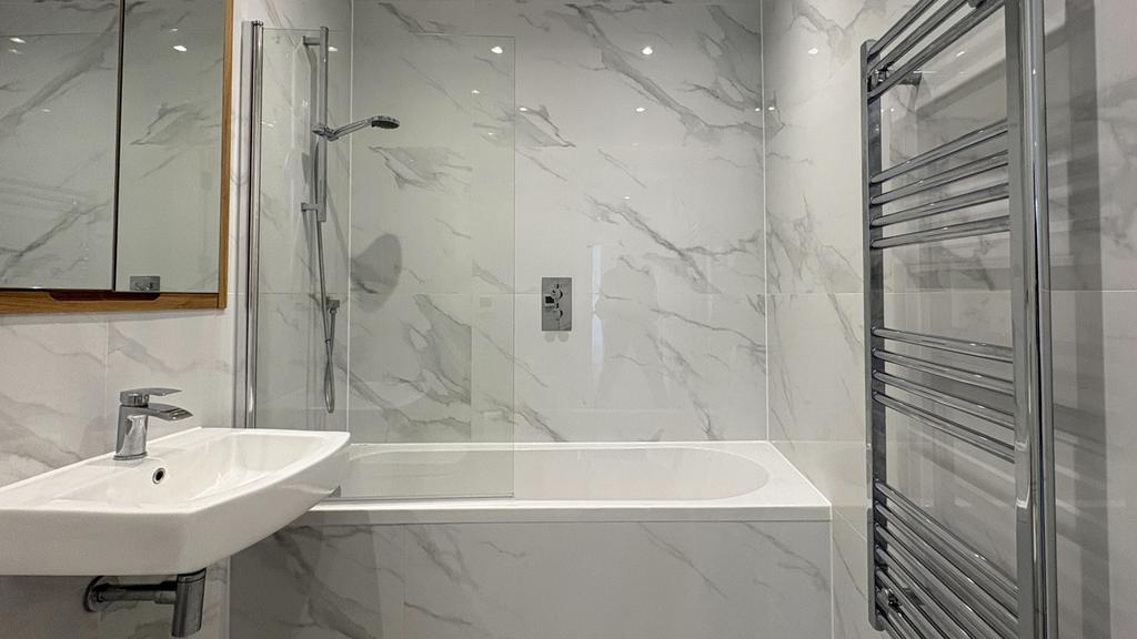 Bright contemporary bathroom with marble-effect...