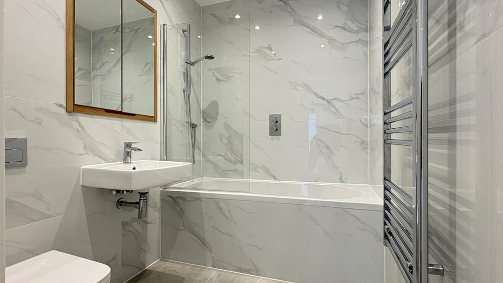 Modern bathroom with marble-effect tiling, a ba...