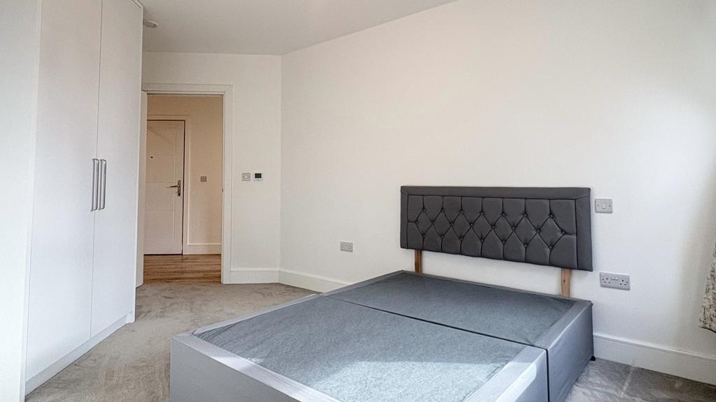 Bright, neutral double bedroom with a modern up...