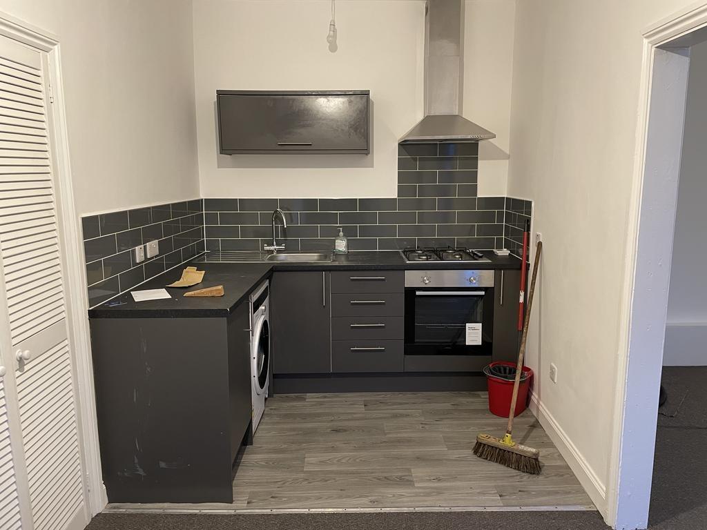 Contemporary kitchenette with dark cabinetry, b...