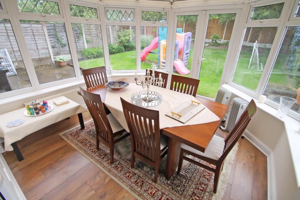 Bright conservatory-style dining area with a wo...