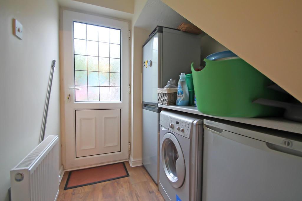 Neat under‑stairs utility area with a front doo...