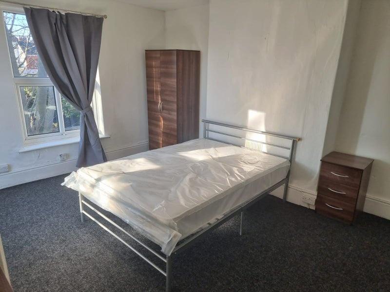 Bright, well-lit bedroom with a metal double be...