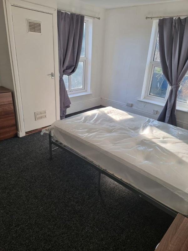 Bright bedroom with two large sash windows, fit...