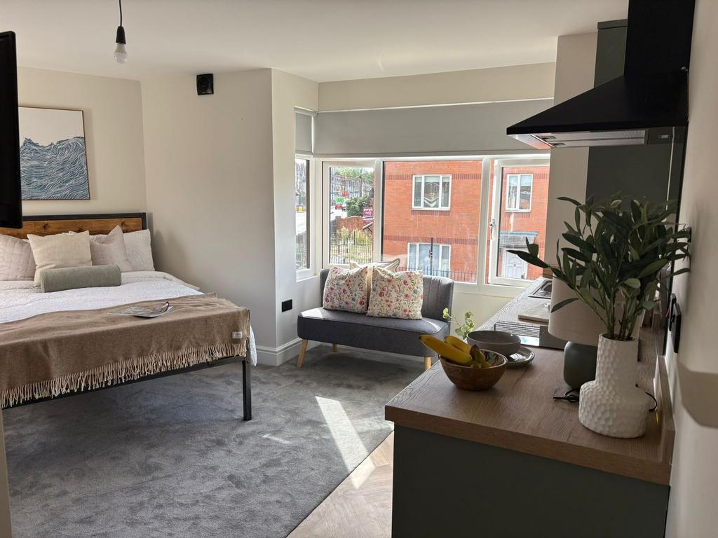 Bright, well-styled studio-style bedroom with a...