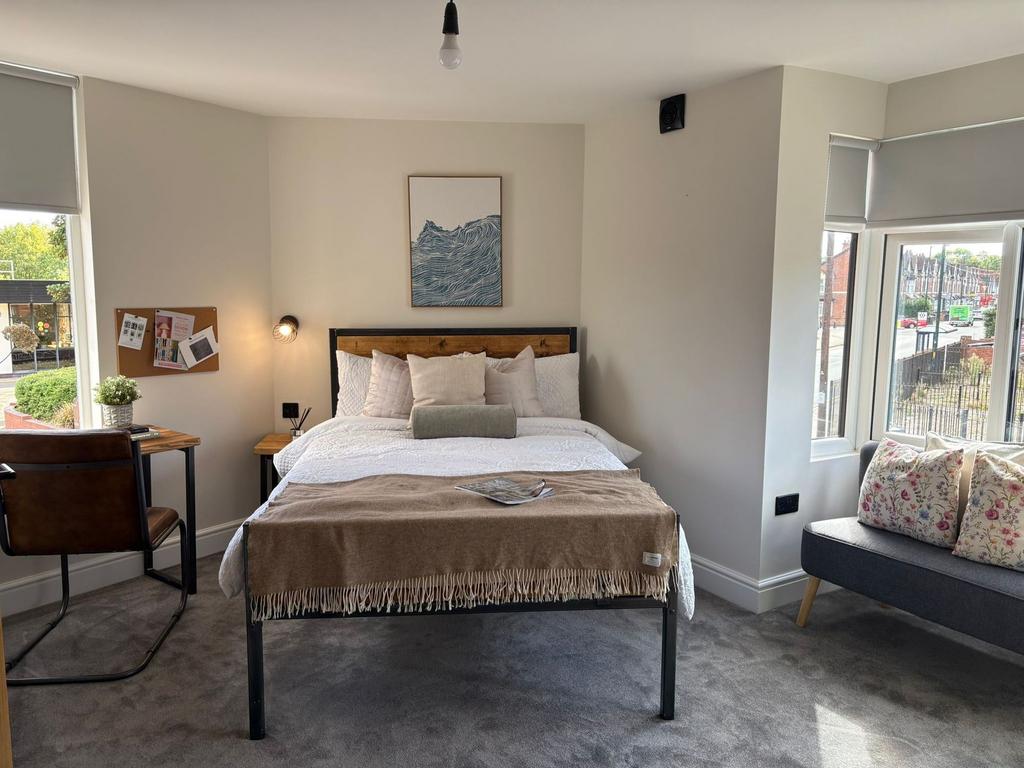 Bright, neatly styled double bedroom with a com...