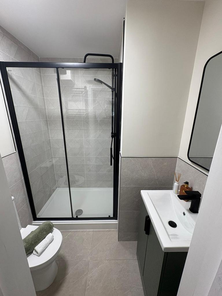 Contemporary bathroom with a glass-framed showe...