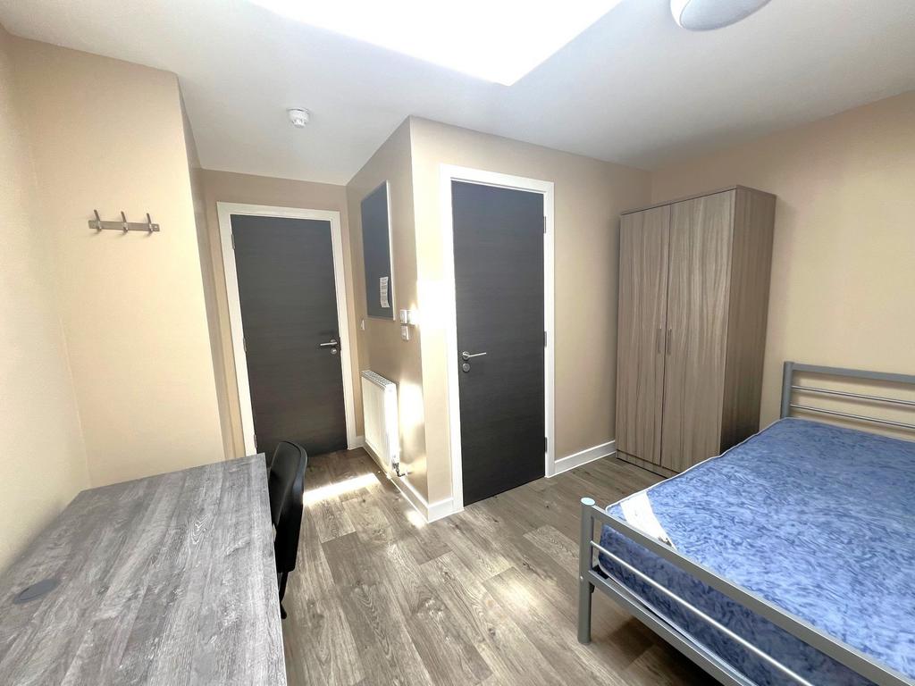 Bright, well-kept bedroom with a large skylight...