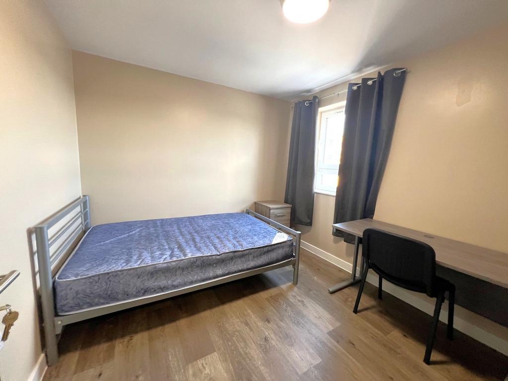 Bright, simply furnished double bedroom with a ...
