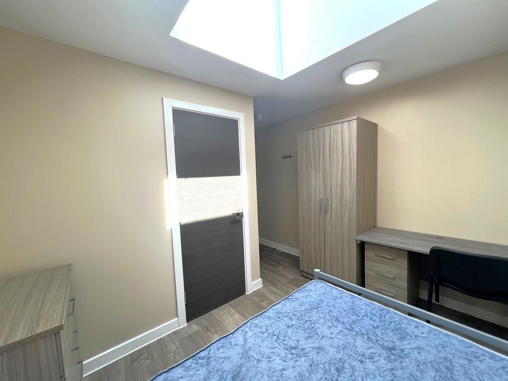 Bright, modern bedroom with a skylight, neutral...