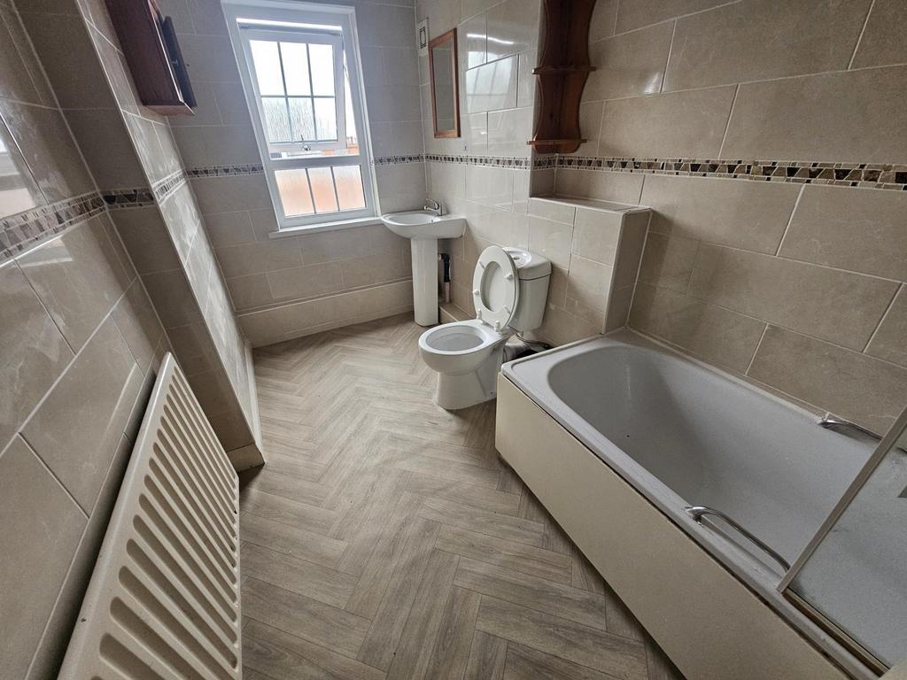 Bright, modern bathroom with neutral tiles, a b...