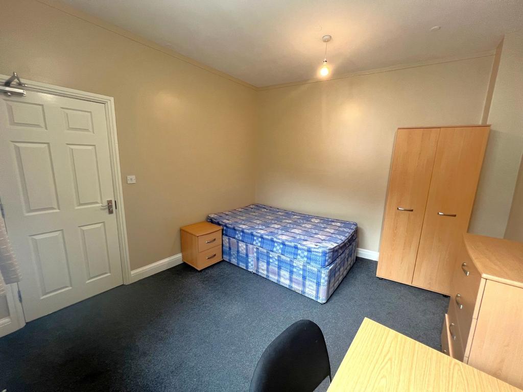 Bright, simply furnished bedroom with a single ...