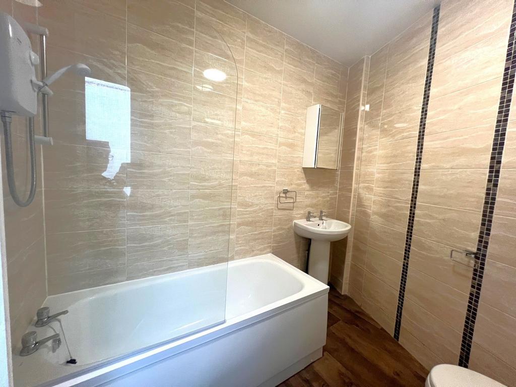Modern tiled bathroom with a fitted bath and sh...