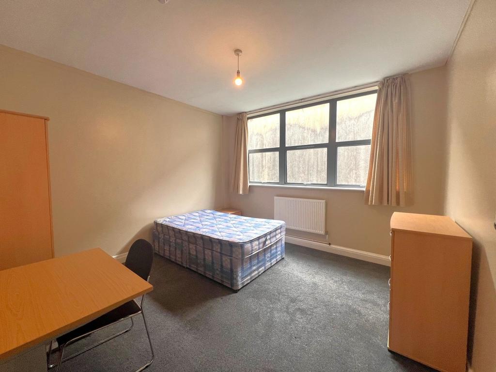 Bright single bedroom with a large window provi...