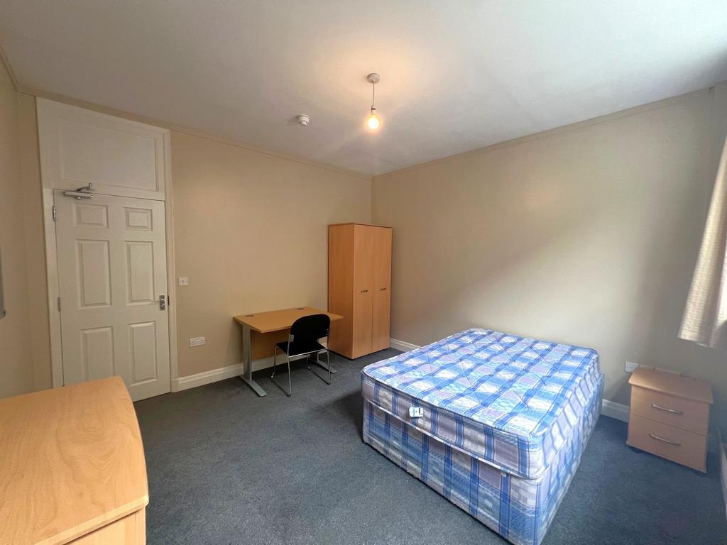Bright, simply furnished double bedroom with a ...