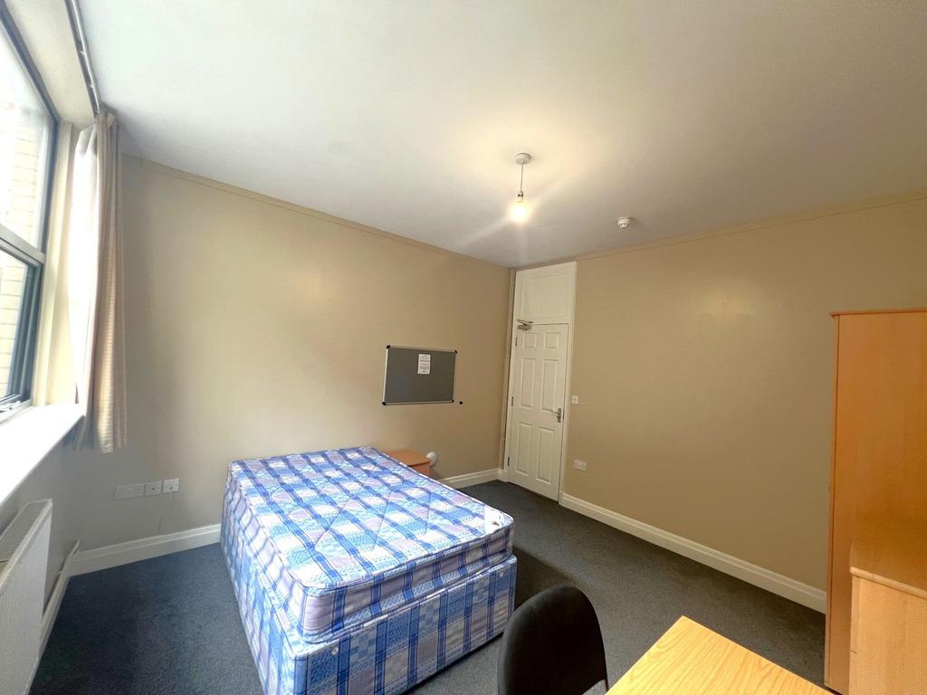 Bright, neatly presented bedroom with a large w...