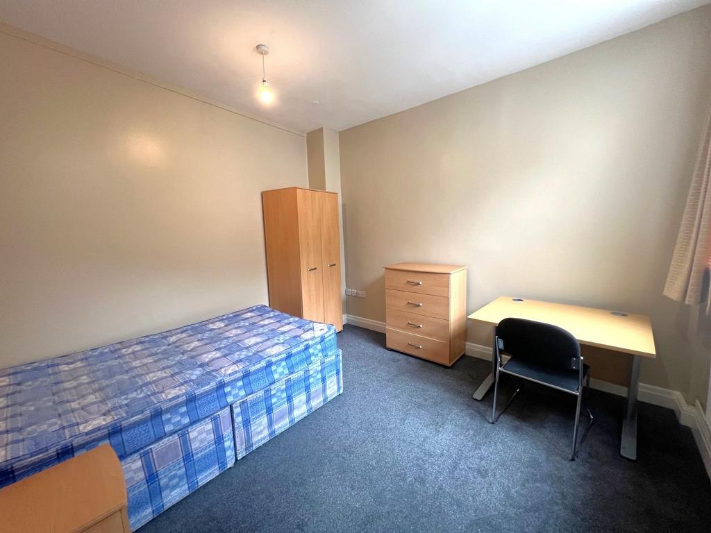 Bright, simply furnished single bedroom with a ...