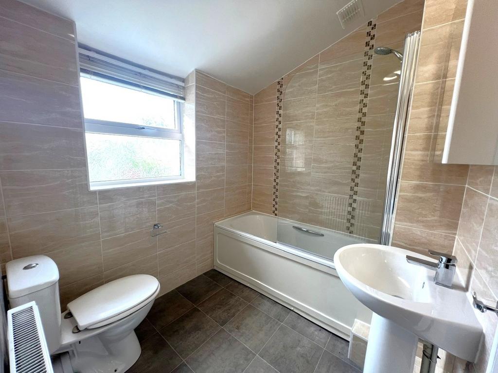 Bright, modern bathroom with large frosted wind...
