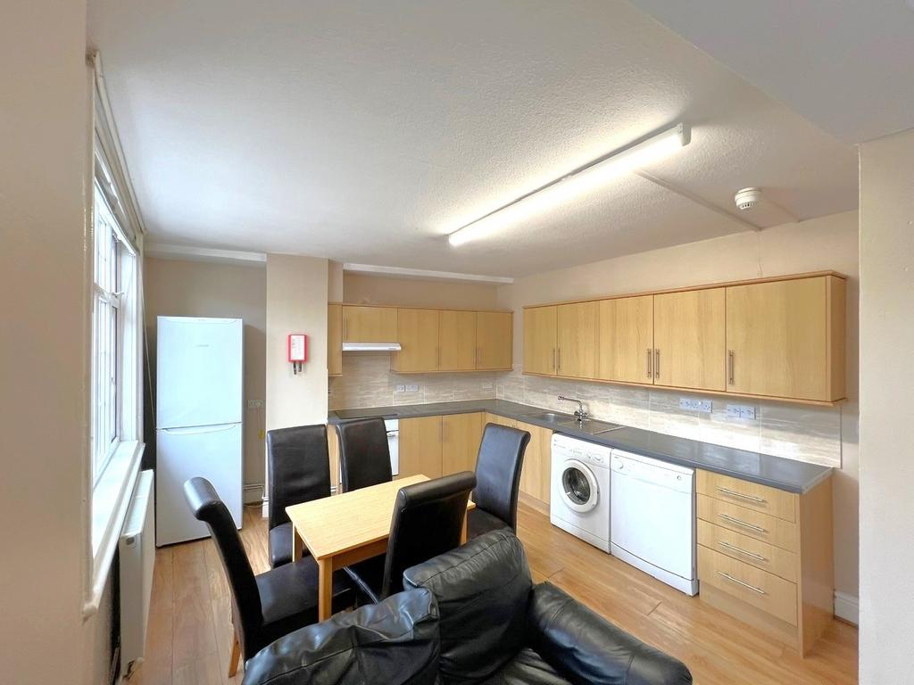Bright open-plan kitchen with light wood cabine...