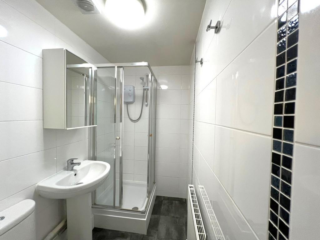 Bright, modern bathroom with a corner shower en...