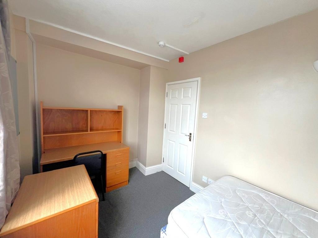 A neatly maintained single bedroom featuring a ...