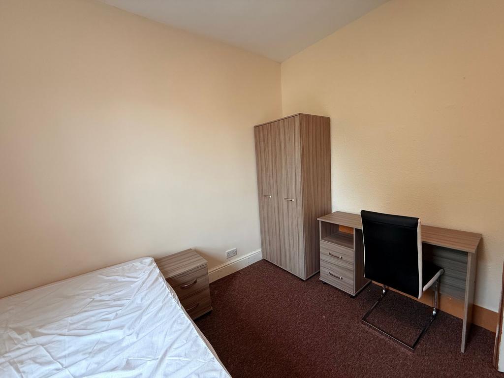 Bright, simply furnished bedroom with a single ...