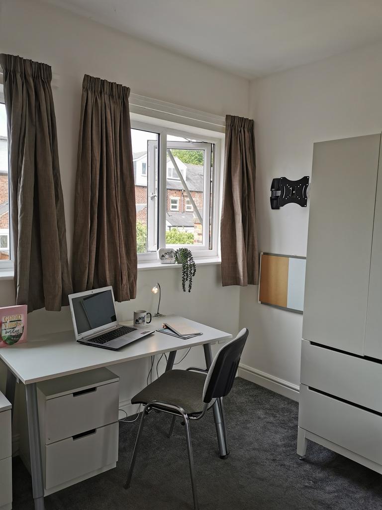 Bright, tidy workspace with a desk by a large w...